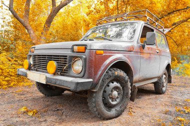 Offroad vehicle in autumn forest clipart