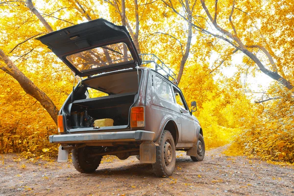 Offroad vehicle in autumn forest — Stock Photo, Image