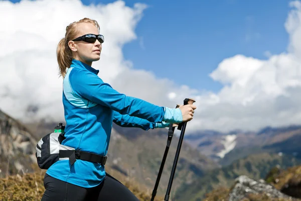 Kadın Nordik yürüyüş ve egzersiz dağlarda — Stok fotoğraf