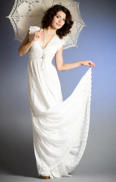 Молода жінка в ретро весільній сукні з парасолькою — стокове фото
