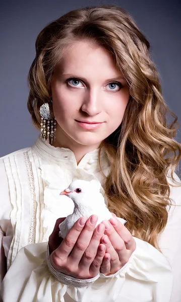 Güzel bir kadın ile koyu arka plan üzerinde beyaz güvercin — Stok fotoğraf