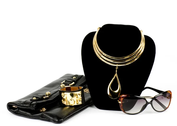 Модная сумочка и золотые украшения, очки на белом фоне . — стоковое фото