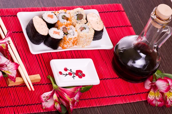 Set sushi rolt op de witte plaat met bloemen — Stockfoto