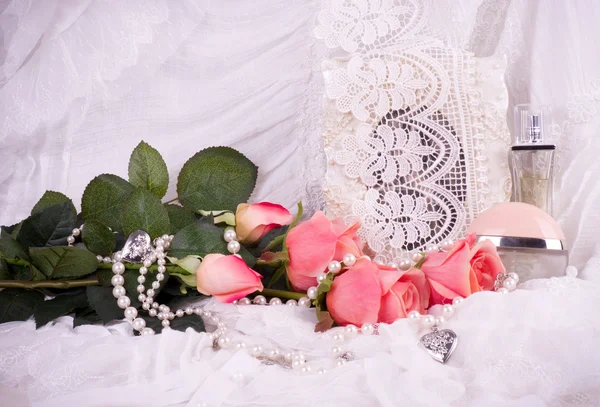 Vackra parfymflaskor, rosa rosor och ram — Stockfoto