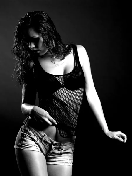 Piękna młoda kobieta w mokrej koszuli na ciemnym tle — Zdjęcie stockowe