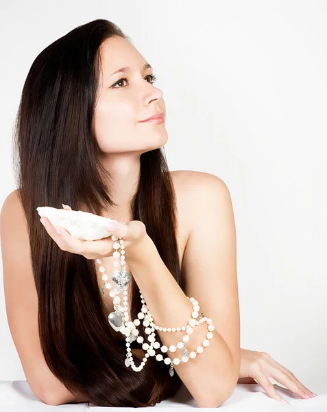 Mooie jonge vrouw met exotische shell en parels — Stockfoto