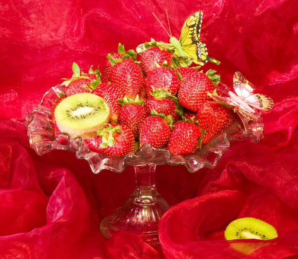 红色背景上的花瓶里的红色新鲜草莓 — 图库照片