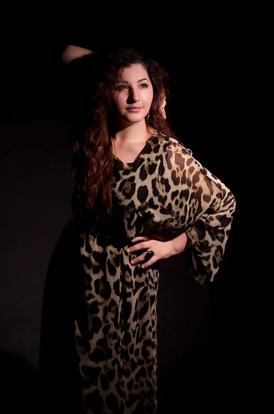 Sexy jonge vrouw in de mode jurk op donkere achtergrond. — Stockfoto