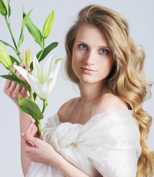 Krásná mladá žena s bílým lily na pozadí — Stock fotografie