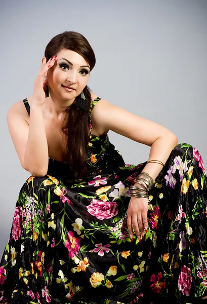 Mooie vrouw in jurk met Lentebloemen — Stockfoto