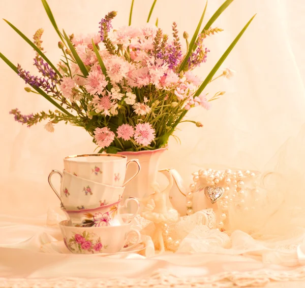 Vintage teacups, ballet dancer statuette and flowers — Stock Photo, Image