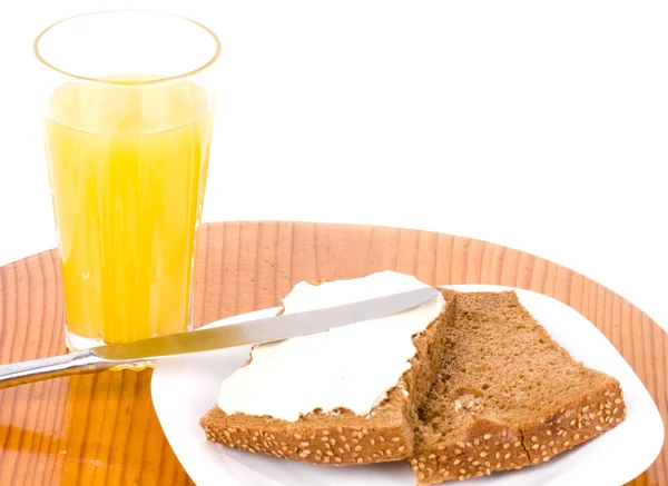 Tasty bread with butter and orange juice — Stockfoto