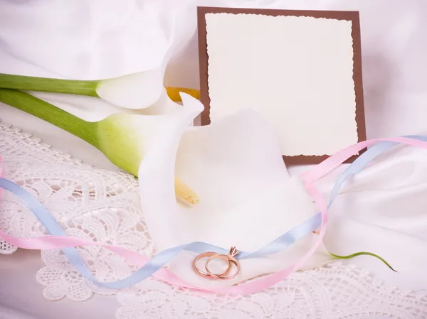 Vackra vita callas med banner lägga och bröllop gyllene ringar — Stockfoto