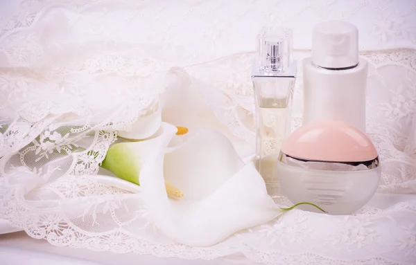 Vackra vita callas med parfymflaskor — Stockfoto