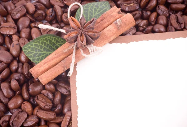 Кофейные зерна и корица с бумажным баннером — стоковое фото