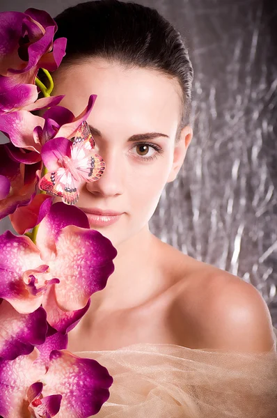 Skönhet ansikte av den unga kvinnan med blomma — Stockfoto
