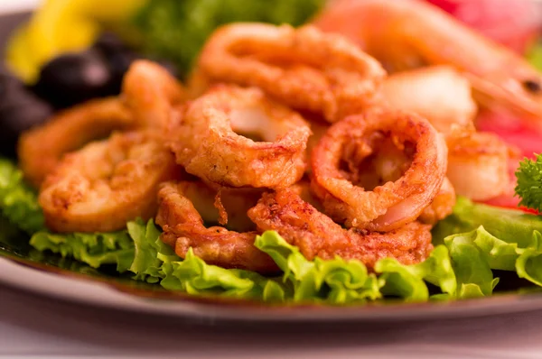 Smakelijke diepe gebakken inktvis ringen met groenten — Stockfoto