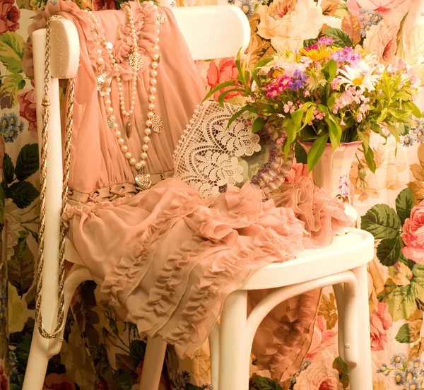 Vintage vestido elegante, copo e flores na cadeira branca — Fotografia de Stock