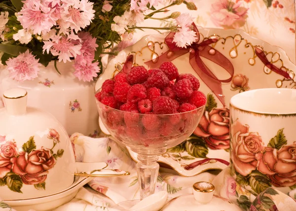 Винтажные элегантные чашки, малина и цветы — стоковое фото