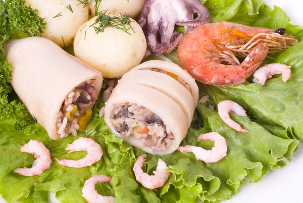 Кальмар с креветками и овощами на листе салата — стоковое фото