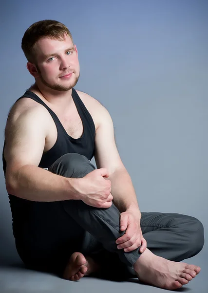 Młody człowiek mięśni na ciemnym tle — Zdjęcie stockowe