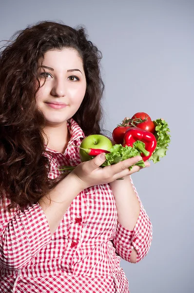 Vrouwelijke vegetarische met groenten op de achtergrond — Stockfoto