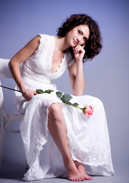 Młoda kobieta w sukni ślubnej z różą — Zdjęcie stockowe
