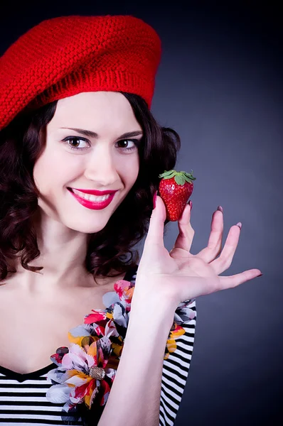 Young woman with strawberry in red beret — Stock Photo, Image