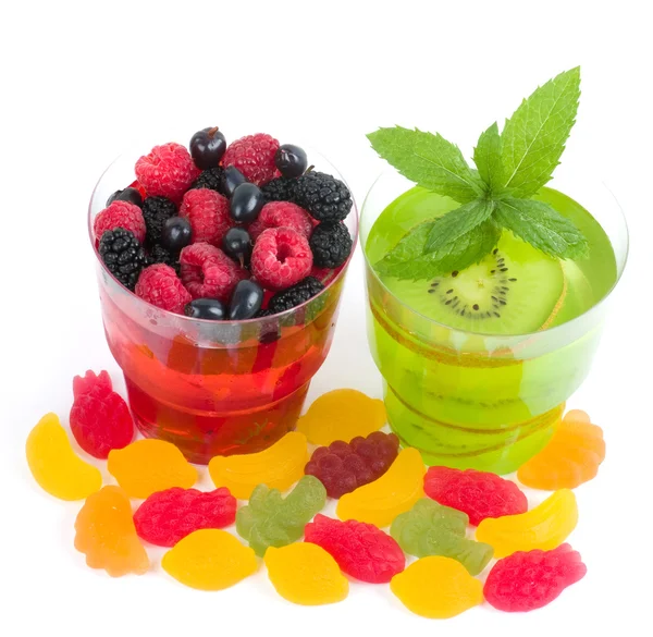 Gelatina colorida sabrosa con frutas, bayas y caramelos sobre un fondo blanco —  Fotos de Stock