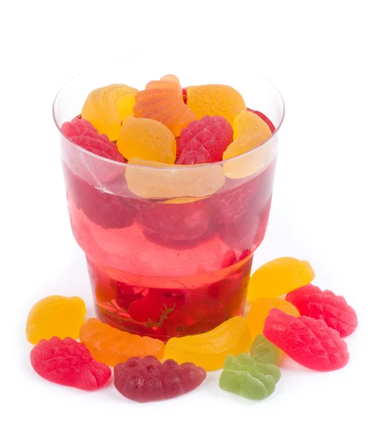 Smakelijke kleurrijke gelei met snoepjes op een witte achtergrond — Stockfoto