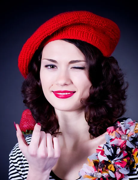 Mladá žena s jahodou v červený baret — Stock fotografie