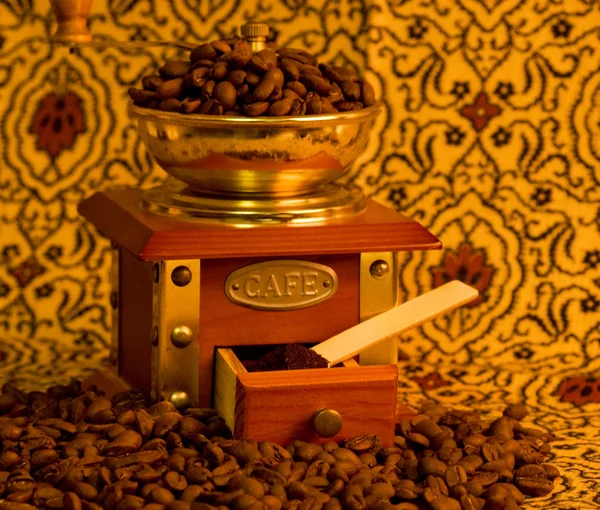 Старинная кофемолка с кофейными зёрнами — стоковое фото