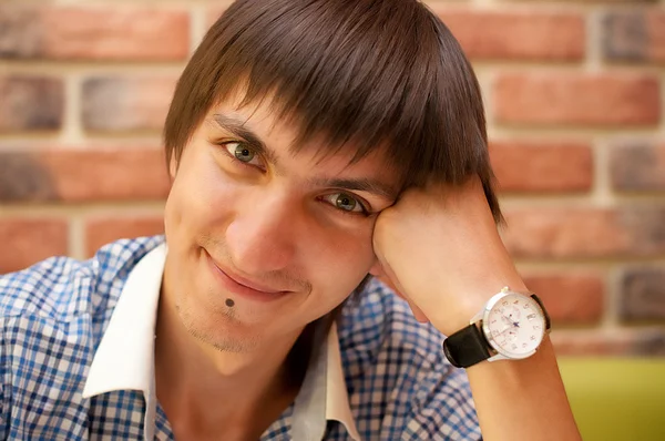 Junger erwachsener Mann mit Uhr sitzt im Café — Stockfoto
