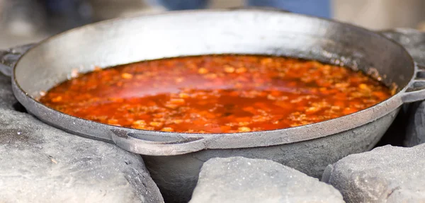 Tasty soup lagman in cauldron on stone — Stock Photo, Image