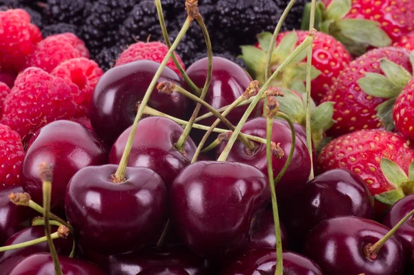 Berry mix pozadí - maliny, moruše, jahody a třešně — Stock fotografie