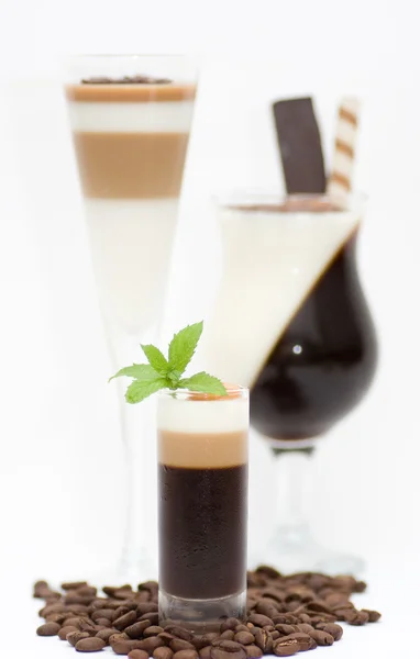 Sobremesa saborosa com grãos de café no fundo branco — Fotografia de Stock