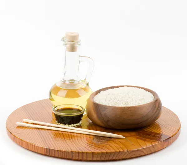 Чаша сырого риса и бутылка оливкового масла для японской еды — стоковое фото