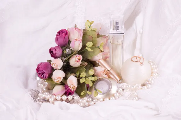 Beautiful perfume bottles, pink roses and beads — Stock Photo, Image