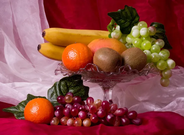 Vackra komposition med frukter på röd bakgrund — Stockfoto