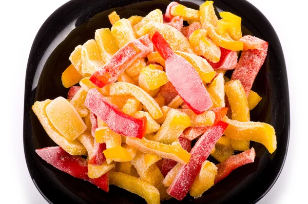 Pimienta roja y amarilla en plato negro en el fondo — Foto de Stock