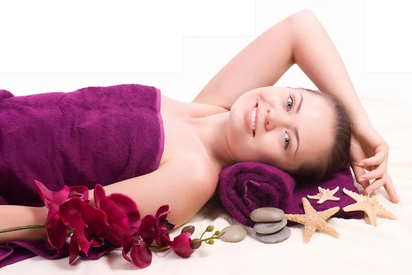 Schoonheid Wellness vrouw met handdoek en roze orchid op achtergrond — Stockfoto