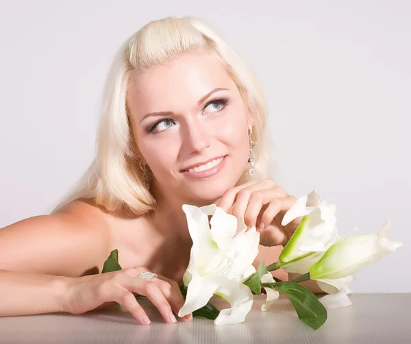 Gezicht van de schoonheid van de jonge vrouw met witte lelie op achtergrond — Stockfoto