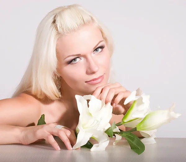 Bellezza viso della giovane donna con giglio bianco su sfondo — Foto Stock