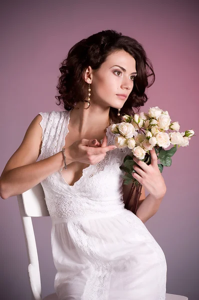 Νεαρή γυναίκα σε λευκό νυφικό φόρεμα με λουλούδια — Φωτογραφία Αρχείου