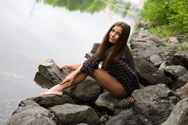 Sexy young girl on the stone banks of the River — Stock Photo, Image