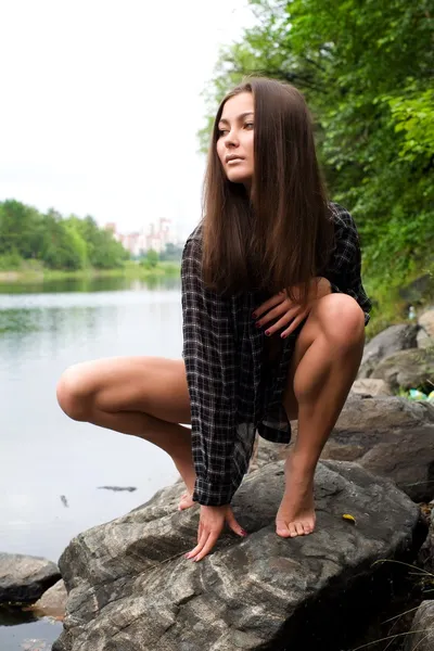 Sexy chica joven en las orillas de piedra del río — Foto de Stock