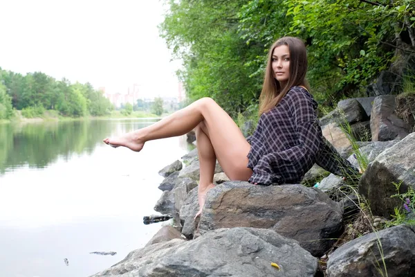 Sexy meisje op de stenen oevers van de rivier — Stockfoto