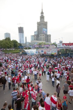 WARSAW, POLAND - JUNE 16: Polish fans at Warsaw streets before UEFA EURO 2012 Poland vs. Czech Republic football match, with Palace of Science and Culture in backgorund, June 16, 2012 in Warsaw, Polan clipart