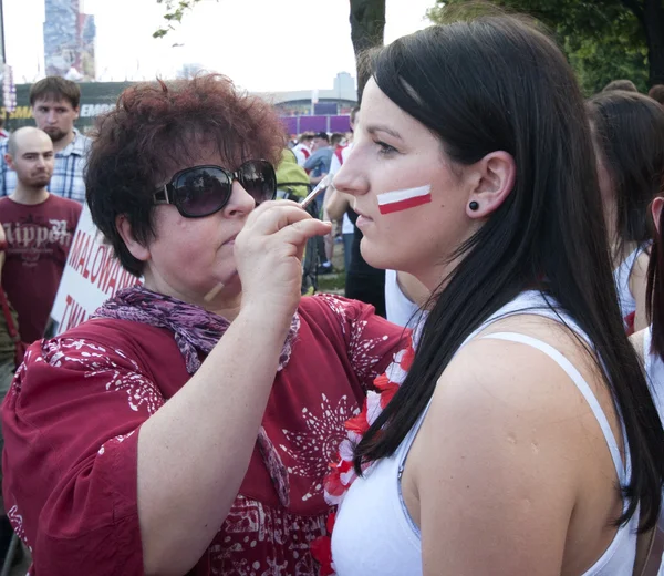 ВАРШАВА, ПОЛЬША - 16 июня: Польский фанат рисует лица перед футбольным матчем с Чехией 16 июля 2012 года в Варшаве, Польша. Евро-2012 принимают Польша и Украина . — стоковое фото