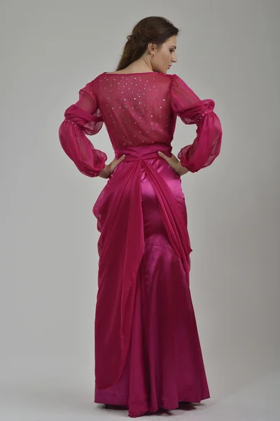Elegant kvinna i fashionabla klänning poserar i studion Stockbild